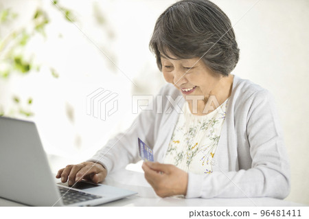 在電腦上享受網上購物的高級女性 96481411