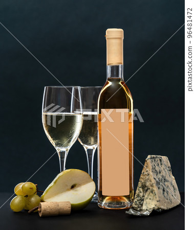 composition with glass and bottle of white wine with blue mold cheese, pear and grapes on grey background. copy space composition with glass and bottle of white wine with blue mold cheese, pear and grapes on grey background. copy space 96481472