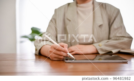 A professional female boss working at her office desk, using a digital tablet. cropped shot A professional female boss working at her office desk, using a digital tablet. cropped shot 96481982