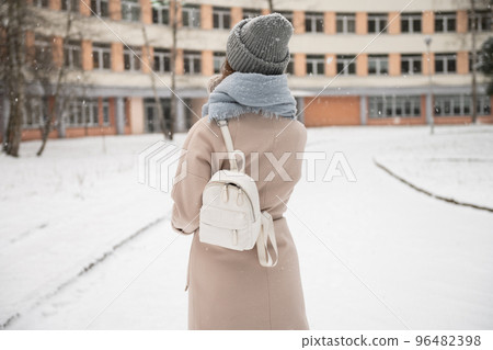 Student girl with backpack goes to study in winter 96482398