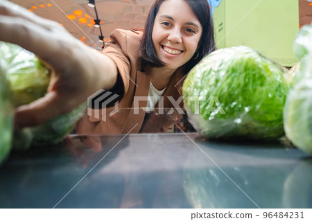 Woman looking for vegetable Taking Products From Shelf Couple Customers Shopping With Checklist 96484231