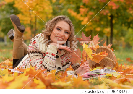 Beautiful girl on the grass in the park in autumn 96484233