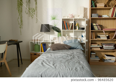 Horizontal image of child bedroom with modern design with cozy bed, bookcase and desk in the corner of room Horizontal image of child bedroom with modern design with cozy bed, bookcase and desk in the corner of room 96485620