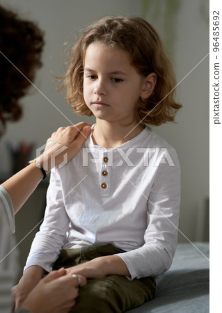 Upset little boy listening to his mom while she talking about his bad behavior Upset little boy listening to his mom while she talking about his bad behavior 96485692