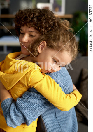 Little boy with sad expression embracing his mother after their communication in room Little boy with sad expression embracing his mother after their communication in room 96485733
