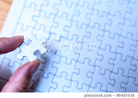 Jigsaw puzzle background texture Hand holding 1 remaining piece Last piece blue 96485936