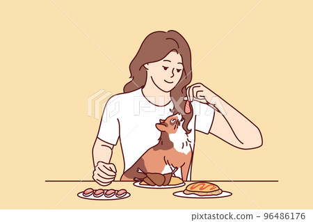 Smiling woman feeding cat from table  96486176