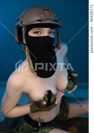sexy soldier girl with grenades on her bare chest wearing a helmet 96486571
