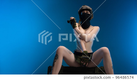 sexy soldier girl with grenades on her bare chest wearing a helmet 96486574