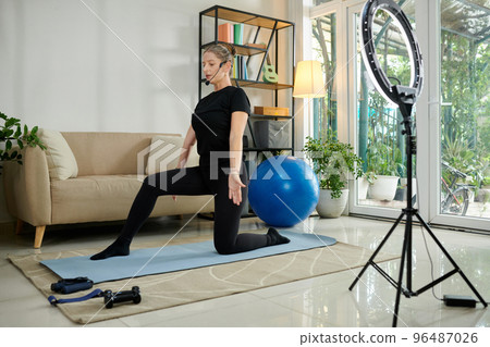 Online fitness instructor speaking in microphone when recording video for blog 96487026