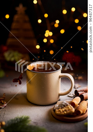 Mug of hot chocolate with splash surrounded by Christmas decorations Mug of hot chocolate with splash surrounded by Christmas decorations 96487317