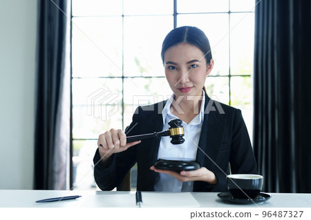Portrait of a beautiful Asian lawyer studying a lawsuit for a client before going to court. 96487327