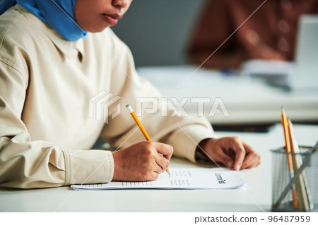 Hand of young Muslim female student with pencil 96487959