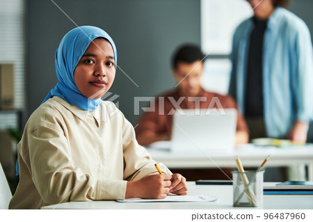Young Muslim woman in blue hijab checking or carrying out test 96487960