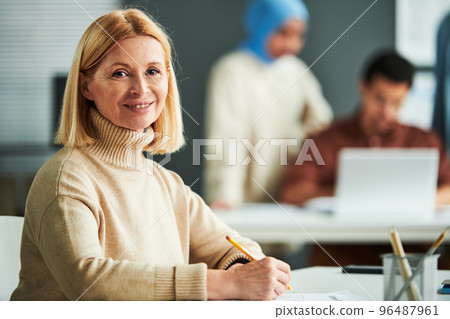 Successful experienced teacher checking exam tests of students 96487961