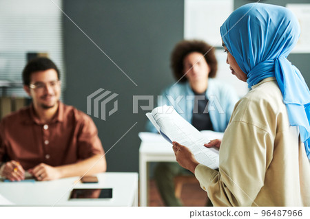 Young Muslim teacher in blue hijab looking at text in document Young Muslim teacher in blue hijab looking at text in document 96487966