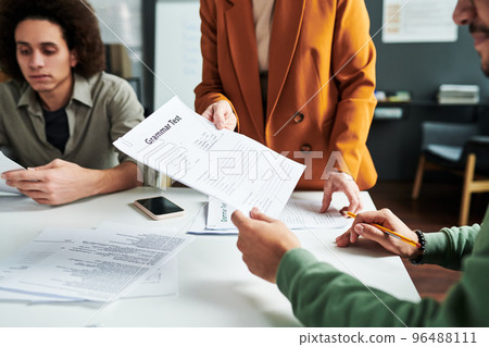 Document with English grammar test being passed by teacher 96488111