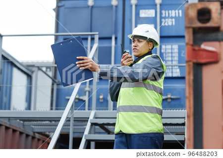 Female foreman wearing hardhat and speaking to radio 96488203