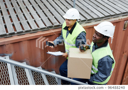 Two workers carrying boxes 96488240