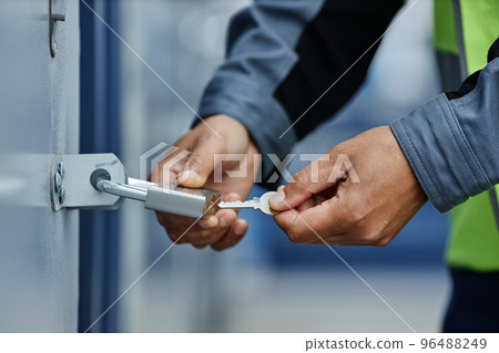 Close up of worker opening hanging lock 96488249