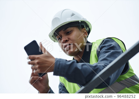 Low angle portrait of female worker against sky 96488252
