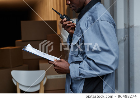 Closeup of male worker checking containers 96488274