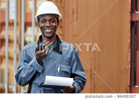 Black man smiling at camera while working at shipping docks Black man smiling at camera while working at shipping docks 96488307