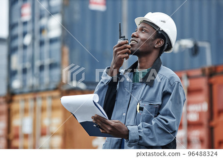 Side view portrait of young black man using walkie talkie 96488324