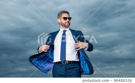 Businessman wearing open suit jacket fluttering in wind sky background Businessman wearing open suit jacket fluttering in wind sky background 96488326