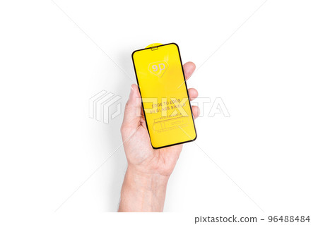 The hand holds a protective screen for a mobile phone. White background. Close-up. 96488484