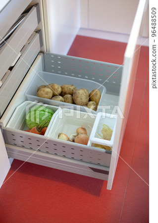Storing vegetables in the kitchen. Storing vegetables in the kitchen. 96488509