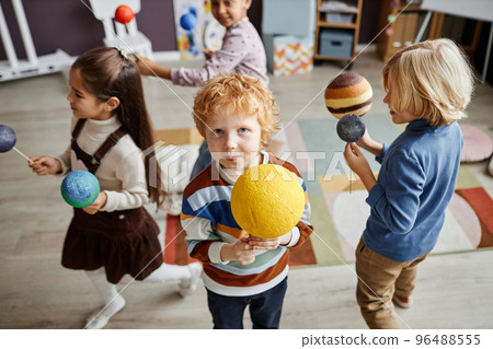 Selective focus on cute little boy holding model of sun 96488555