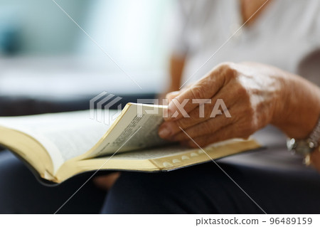 Closeup of senior woman's hands on bible, folded in prayer Closeup of senior woman's hands on bible, folded in prayer 96489159