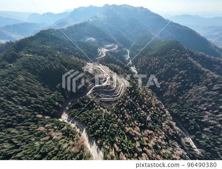 Industrial mine excavators are digging the soil in the construction site and loading trucks. Aerial drone top view. Industrial mine excavators are digging the soil in the construction site and loading trucks. Aerial drone top view. 96490380