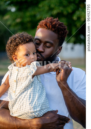 Affectionate dad kissing his child on the cheek Affectionate dad kissing his child on the cheek 96492795