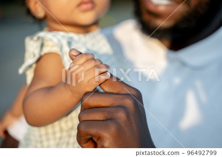 African American male parent with his daughter outside 96492799