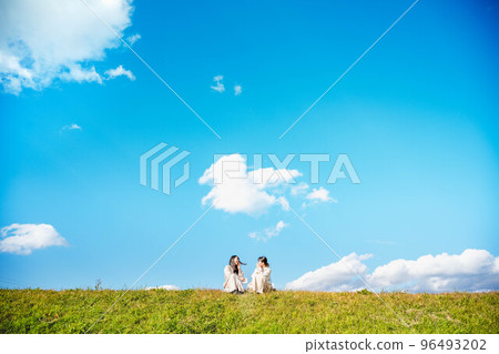 A woman eating croquettes with her friends under the blue sky A woman eating croquettes with her friends under the blue sky 96493202