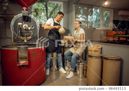 Couple of joyous roast masters working together Couple of joyous roast masters working together 96493513
