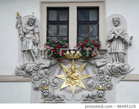 Madonna and Child surrounded by saints on the facade of the House of the Golden Well in Prague 96495129