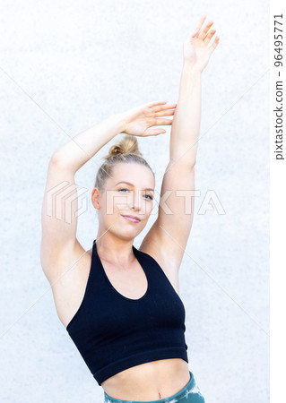 Beautiful young blonde fitness woman wearing blaack and blue sports clothes stretching and full body Beautiful young blonde fitness woman wearing blaack and blue sports clothes stretching and full body 96495771