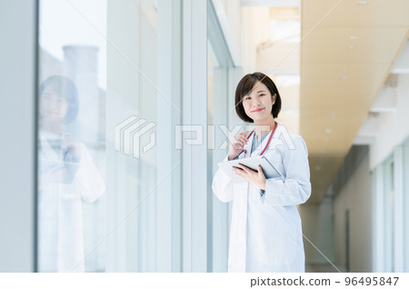 Female doctor walking in the corridor Female doctor walking in the corridor 96495847