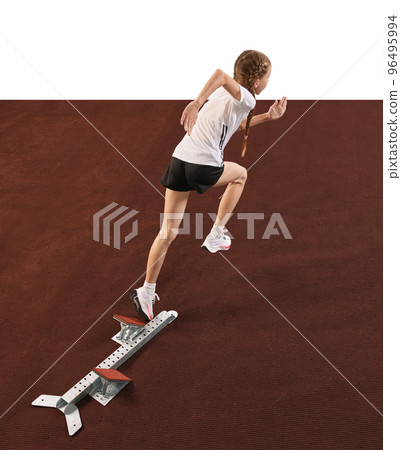 Young athlete, beginner female track runner bursting off starting block isolated over white background. Sport, workout, skills. Back view 96495994