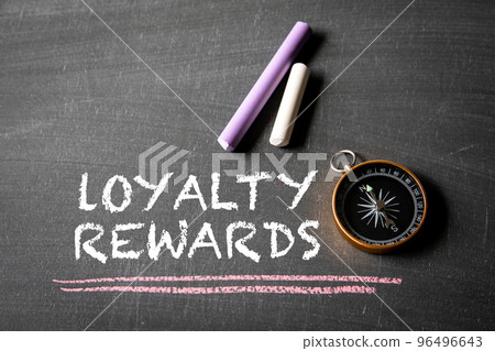 Loyalty Rewards. Text, compass and colored pieces of chalk on blackboard background 96496643