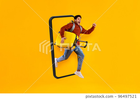 Glad excited young european guy tourist with suitcase and backpack jumping out of huge smartphone Glad excited young european guy tourist with suitcase and backpack jumping out of huge smartphone 96497521