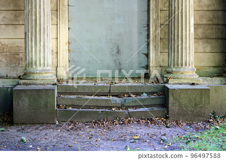 A closeup of an old broken stone staircase of a tomb in a cemetery 96497588