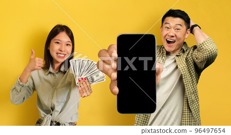 Happy korean couple recommending gambling mobile app, mockup 96497654