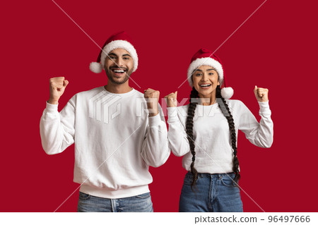 Portrait Of Overjoyed Arab Couple Wearing Santa Hats Celebrating Success Together Portrait Of Overjoyed Arab Couple Wearing Santa Hats Celebrating Success Together 96497666