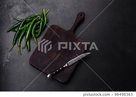 Hot pepper of green color on a dark concrete background 96498363