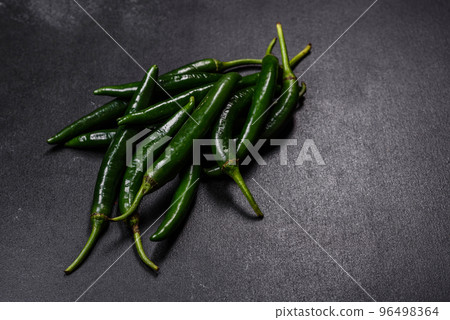 Hot pepper of green color on a dark concrete background 96498364
