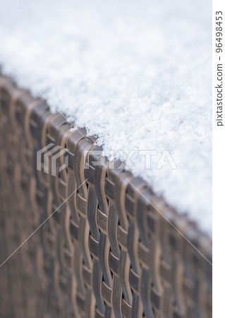 Care and storage of garden furniture in winter. texture of street furniture in winter. Artificial rattan covered with snow close-up. Care and storage of garden furniture in winter. texture of street furniture in winter. Artificial rattan covered with snow close-up. 96498453